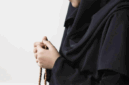Ilustrasi wanita muslim berzikir sambil memegang tasbih. (Foto: Freepik)