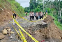 Kapolres Agam AKBP Muari sedang meninjau jalan yang terban di Labuah Sampiak, Jorong Gunggun, Nagari Salareh Aia, Kecamatan Palembayan, Rabu (24/6/2026). ( poto : ANTARA )