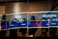 Pekerja berjalan melewati refleksi layar digital pergerakan Indeks Harga Saham Gabungan (IHSG) di Bursa Efek Indonesia, Jakarta, Senin (2/2/2026). (ANTARA FOTO/Sulthony Hasanuddin)