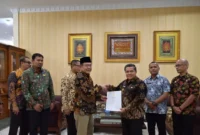 Wali Kota Payakumbuh Zulmaeta menyerahkan bantuan keuangan sebesar Rp1 miliar kepada Bupati Agam Benny Warlis di Rumah Dinas Wali Kota Payakumbuh, Kamis (25/6). (poto : padek.jawapos.com )