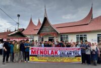 Warga Pandai Sikek, Kabupaten Tanah Datar membentangkan spanduk bertuliskan menolak jalan tol.(poto: istimewa).