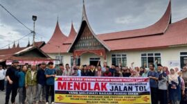 Warga Pandai Sikek, Kabupaten Tanah Datar membentangkan spanduk bertuliskan menolak jalan tol.(poto: istimewa).