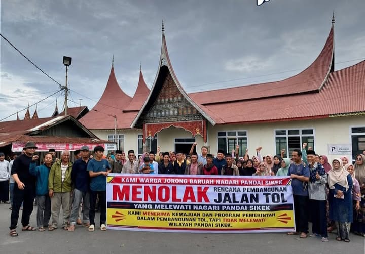 Warga Pandai Sikek, Kabupaten Tanah Datar membentangkan spanduk bertuliskan menolak jalan tol.(poto: istimewa).