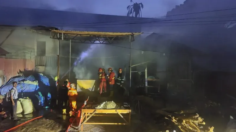 Personel Damkar Kota Padang tengah berupaya memadamkan api yang membakar gudang Kopra.(poto: padangkita.com).