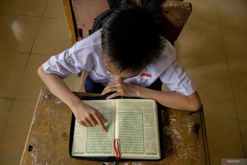  Seorang pelajar membaca Al Quran di salah satu sekolah menengah pertama di Sumatera Barat.(poto: ANTARA).