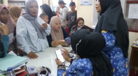 Petugas Dinas Kependudukan dan Pencatatan Sipil (Disdukcapil) Kota Padang memberikan pelayanan administrasi kependudukan kepada warga di loket pelayanan.(poto: koranpadang.com)