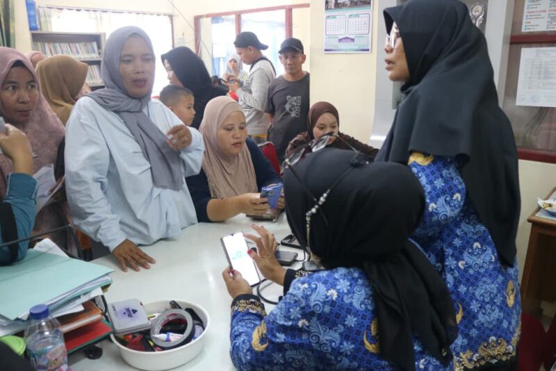 Petugas Dinas Kependudukan dan Pencatatan Sipil (Disdukcapil) Kota Padang memberikan pelayanan administrasi kependudukan kepada warga di loket pelayanan.(poto: koranpadang.com)