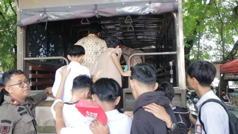 Petugas Satpol PP Kota Padang mengarahkan sejumlah pelajar yang terjaring razia untuk naik ke dalam truk patroli di kawasan Jalan Taman Siswa. (poto: padangkita.com).