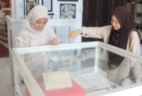 Dua mahasiswi Universitas Andalas tampak antusias saat mengamati koleksi arsip dokumen kuno yang dipamerkan di dalam etalase kaca saat mengunjungi Museum.( poto : padangkita.com )