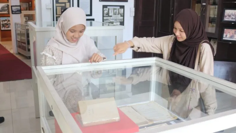 Dua mahasiswi Universitas Andalas tampak antusias saat mengamati koleksi arsip dokumen kuno yang dipamerkan di dalam etalase kaca saat mengunjungi Museum.( poto : padangkita.com )