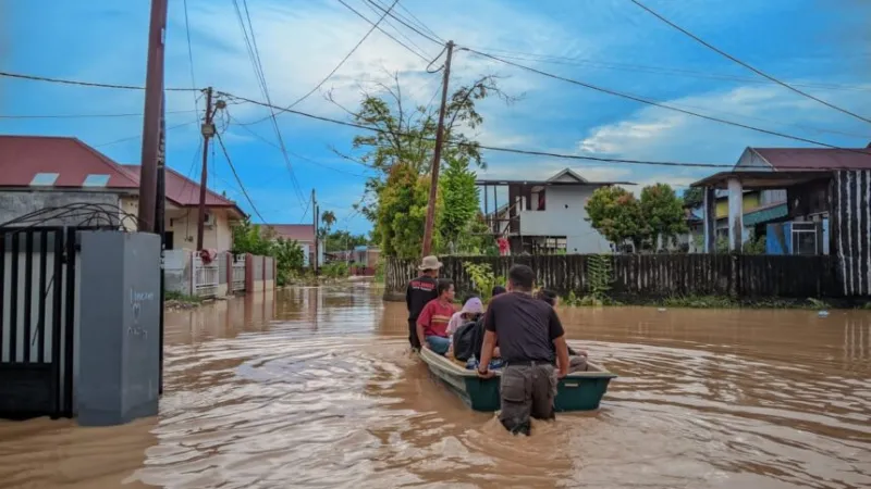 Personel Satpol PP Padang membantu evakuasi warga yang terdampak banjir akibat  cuaca ekstrem.(poto: padangkita.com).