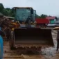 Petugas berjibaku membersihkan material longsor.(poto: fajarsumbar.com).