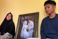 Rika Yunita (39) dan anaknya istri dari Herdiansyah (41) pengemudi Ojol yang meninggal akibat sesak napas terpapar kabut asap kebakaran hutan dan lahan di Sumatera Selatan ketika berada di rumah duka, Sabtu (3/10/2026).(poto: kompas.com).