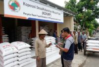 Ilustrasi Petani menunjukkan KTP saat menebus pupuk subsidi melalui aplikasi di Koperasi Desa Merah Putih (KDKMP).(poto: AI).