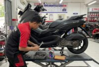 Seorang mekanik sedang melakukan servis rutin dan memeriksa komponen CVT motor Yamaha NMAX di bengkel resmi.(ilustrasi poto: AI).