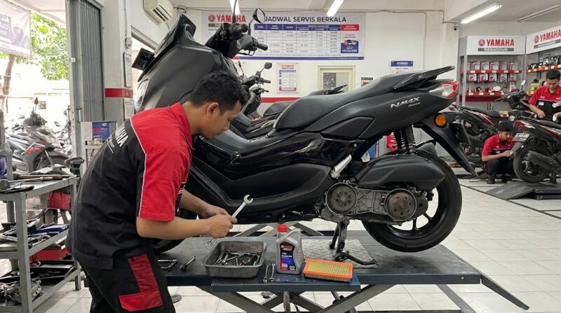 Seorang mekanik sedang melakukan servis rutin dan memeriksa komponen CVT motor Yamaha NMAX di bengkel resmi.(ilustrasi poto: AI).