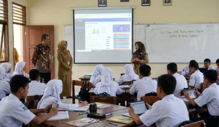 Siswa SMPN 17 Padang menyimak paparan guru mengenai uji coba LMS Ruang Kelas Digital melalui proyektor.