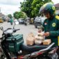 Ilustrasi: Pengemudi ojol menata paket dan makanan di motor di Jakarta. Aturan tarif baru Komdigi segera terbit akhir 2026.(poto: AI).