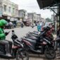 Ilustrasi: Pengemudi ojek online dan ojek pangkalan beraktivitas berdampingan di tepi jalan Kota Sungai Penuh, Jambi.(poto: AI).